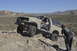 1991 Ford Bronco - Off-road Bronco navigating a challenging rocky trail under a clear blue sky.