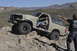 1991 Ford Bronco - A man in a tan Ford Bronco navigates a rocky desert trail while another man points.