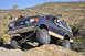 1991 Ford Bronco - This lifted Ford Bronco navigates a desert trail with a large rock formation in the background.