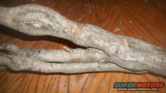 two gray tree branches resting on a wooden table