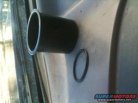Interior door panel with black cup holder and a black o-ring on the textured surface. Supermotors.net logo visible