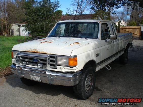 White Ford F-250 pickup truck with rust on the hood and front bumper damage