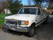 1989 Ford F-250 - This 1987 Ford F-250 pickup truck shows signs of wear and tear, including rust and front bumper damage.
