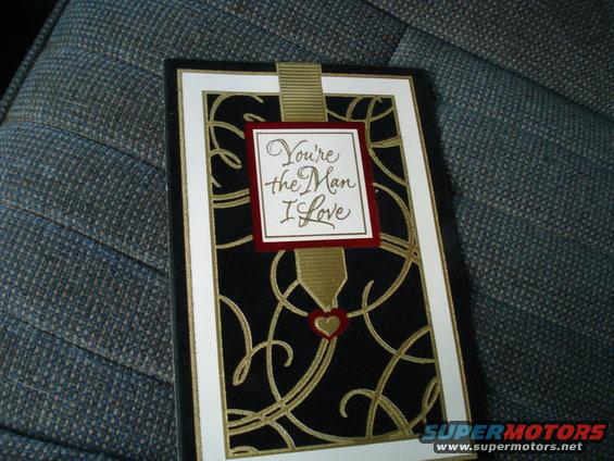 Greeting card with "You're the Man I Love" text, placed on textured upholstery