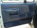 1989 Ford F-250 - The interior door panel of a 1989 Ford F-250 features blue fabric inserts and power window controls.