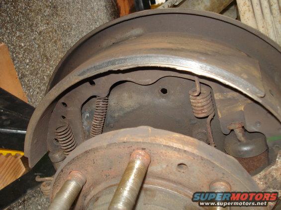 Rusty brake drum and shoes with springs, showing wear and tear