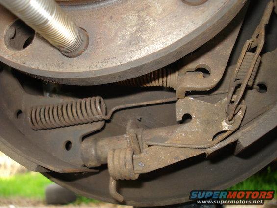 Close-up of a rusty drum brake assembly with springs and linkage