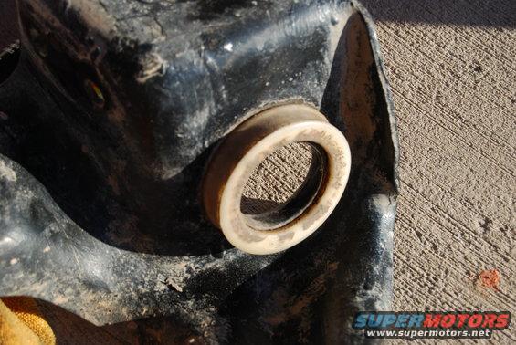 Close-up of a rubber bushing on a black metal part, possibly from a vehicle