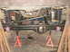 1995 Ford Bronco - Vehicle's rear axle and suspension parts are elevated on jack stands for maintenance.