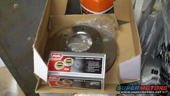 Box with Warn manual locking hubs and a brake rotor inside. Some text on the box is visible