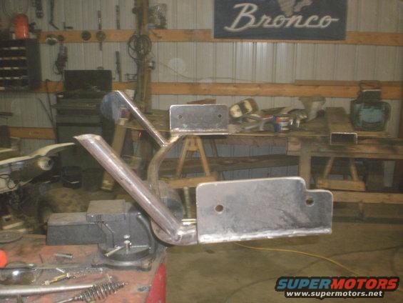 Custom metal bracket held in vise, "Bronco" sign in background