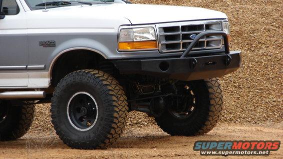 Silver Ford Bronco with aftermarket bumper and large tires