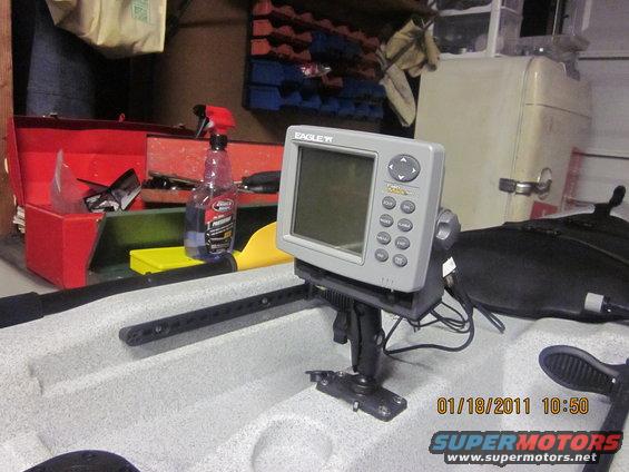 Kayak with a fish finder mounted on it, plus a toolbox and spray bottle in the background