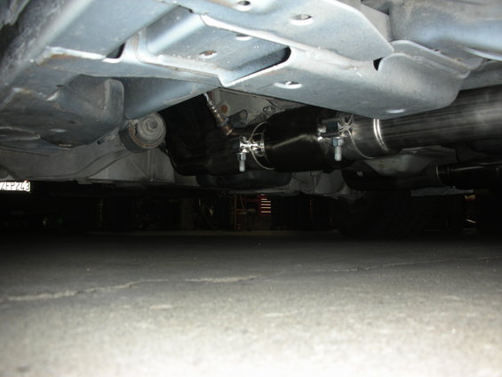 Underbody view of a custom exhaust system with a large muffler