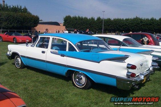 Two-tone white and blue 1959 Dodge Custom Royal sedan parked on grass, rear quarter view