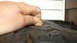 1988 Ford Bronco - A hand inserts a penny into a tire's tread to gauge its remaining depth.