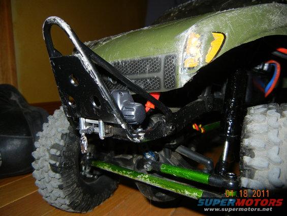 RC car front bumper and green suspension components, close-up
