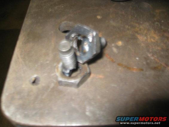 close-up of a metal bracket attached to a bolt with a nut