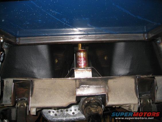 Can of Olde English 800 beer sitting on metal frame inside vehicle