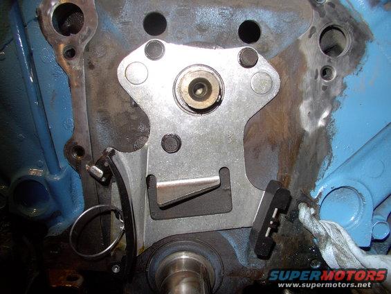 Oops you're done. Yes it's just three bolts and it replaces your original thrust plate and that little pointed tang just about the crank ensures oil flows onto the new chain.