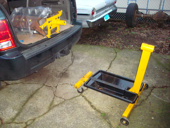 SUV rear with engine parts, vintage car rear, and engine hoist