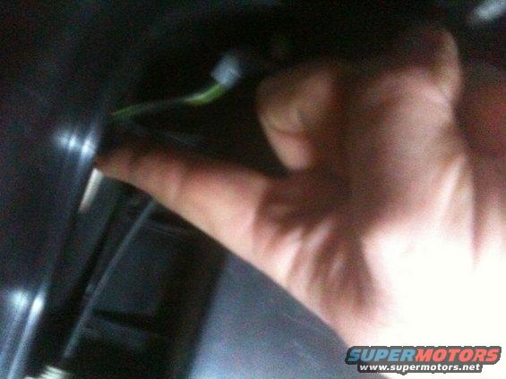 Hand connecting a green wire to a component