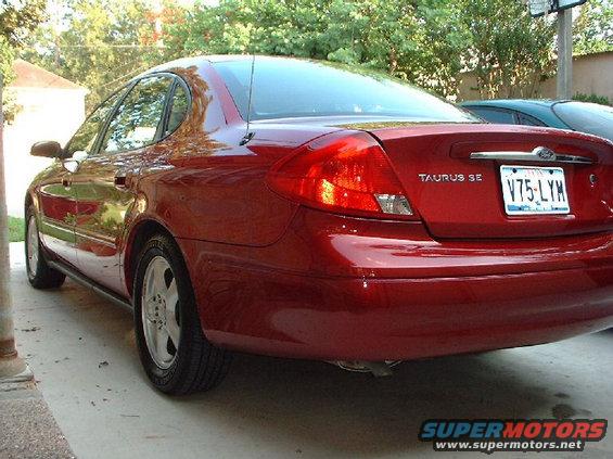 Red sedan's rear view, showing taillights and license plate V75-LYM
