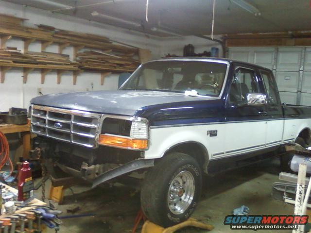 1992 Ford F-150 truck with front end disassembled in a garage