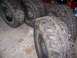 2001 Dodge 1500 - A collection of four large, tires and their rims are displayed on a concrete surface, likely for sale or storage.