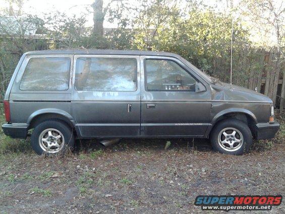 Gray 1989 Dodge Caravan parked on grass, side view. Text on door reads "INTERCOOLED TURBO"