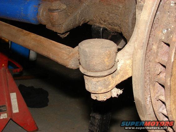 close-up of rusty tie rod end and ball joint assembly on a vehicle's suspension
