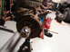 1971 International School Bus - Front axle assembly, likely from a heavy-duty truck, is supported by an engine stand in a garage setting.