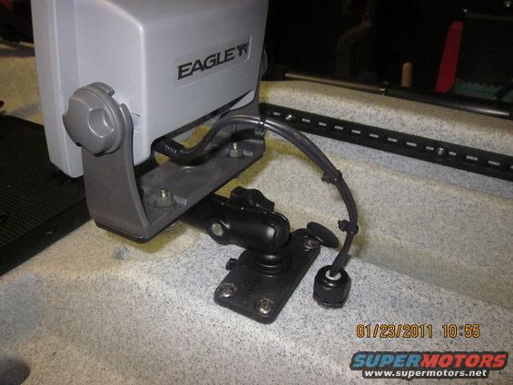 Eagle fish finder mounted on a black bracket with cables attached, set on a textured surface