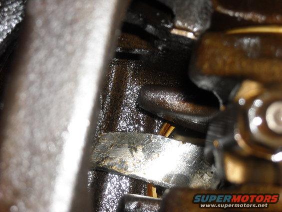Close-up of an oily engine component with metallic and brown surfaces