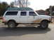 1992 Ford C-350 (Centurion Conversions) - This extended cab pickup truck is equipped with a boat on its roof, ready for an adventure.