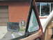 1981 Ford Bronco - The vent window glass is shattered, showing damage to the vehicle's interior.