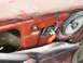 1981 Ford Bronco - Interior view of a vehicle's red door panel, revealing the speaker and window operating mechanism.