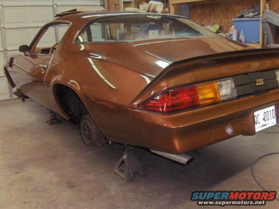Rear view of a brown 1982 Chevrolet Camaro on jack stands in a garage