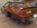 1982 Chevrolet Camaro - The rear of a brown 1982 Chevrolet Camaro is shown on jack stands inside a garage.