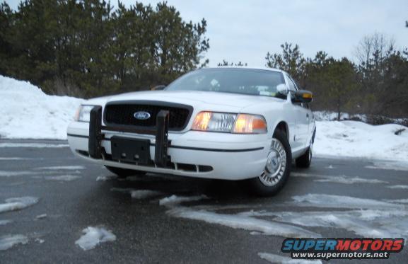 White 1999 Ford Crown Victoria with push bar in snow