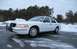 1999 Ford Crown Victoria - A white police car with a push bumper is parked on a wet, icy road during winter.