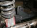 1995 Ford Bronco - Detail of a vehicle's suspension system, showing a coil spring and mounting hardware.