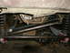 1995 Ford Bronco - Vehicle undercarriage with suspension and differential visible, likely undergoing modifications.
