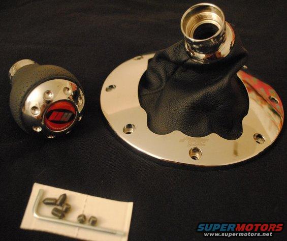 Shift knob with red emblem and chrome accents next to a chrome trim ring with a black leather shift boot. Includes allen wrench and screws