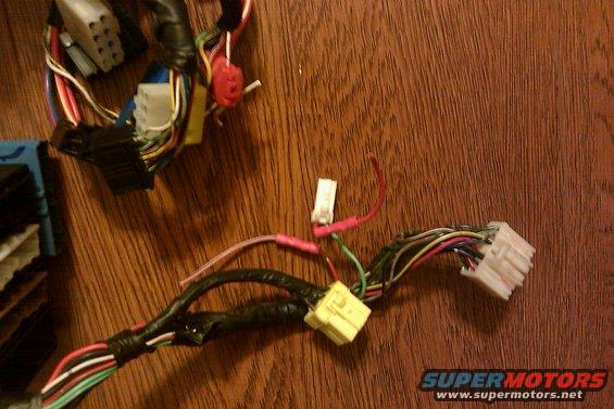 Automotive wiring harness with multiple connectors and colored wires on a wooden surface