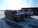 1993 Ford C-150 (Centurion Conversions) - A red extended cab pickup truck with a camper shell is parked next to a white SUV in a snowy lot.