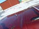 1993 Ford C-150 (Centurion Conversions) - Close-up of a red vehicle's hood, showing an antenna and signs of wear and tear.