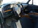 1993 Ford C-150 (Centurion Conversions) - The interior of a truck shows a dashboard with gauges, wood trim accents, and dark fabric seats.