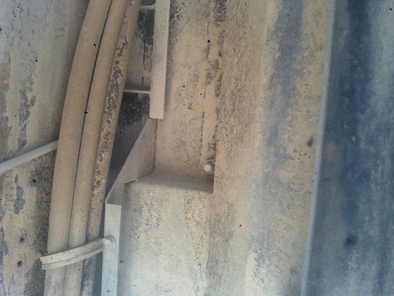 Close-up of dirty underbody with pipes and metal brackets