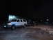 1993 Ford C-150 (Centurion Conversions) - A white extended cab pickup truck is seen towing a trailer in a parking lot at night.